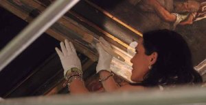 La restauradora consolida las pinturas de los techos del Salón de los Arzobispos.